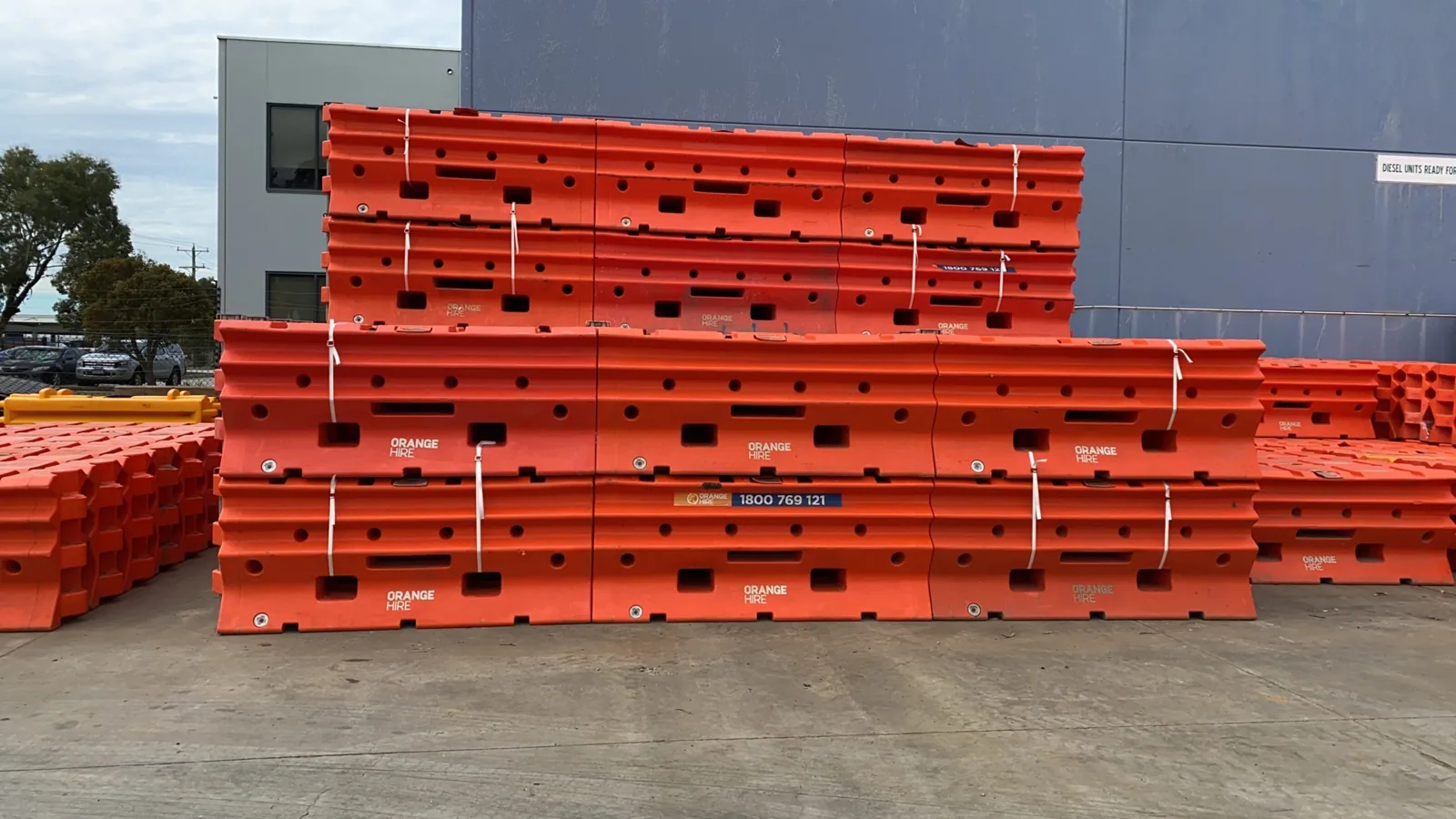 Stockpile of construction materials neatly arranged on-site, ready for use, with safety barriers and labels in place.