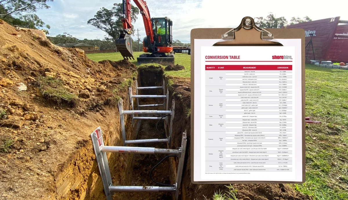Construction machine near a trench with a conversion table displayed, aiding in accurate measurements and safe installation.