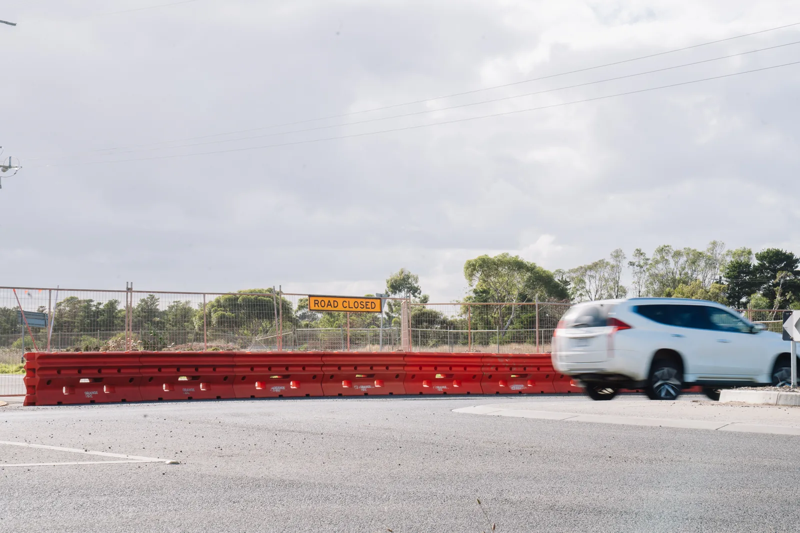 car driving past water filled barriers