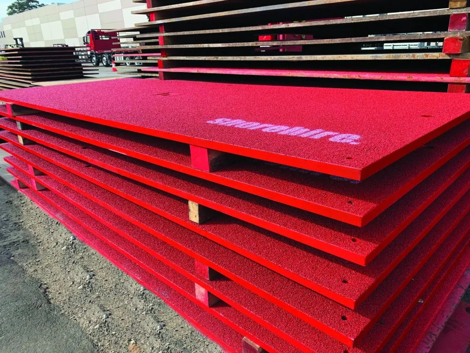 Stack of steel plates organized on-site, ready for use in construction with proper safety and handling procedures in place.