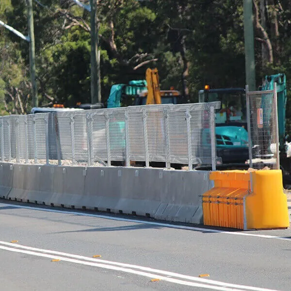 Safety barriers installed along a roadside construction area to protect workers and guide traffic through the work zone.