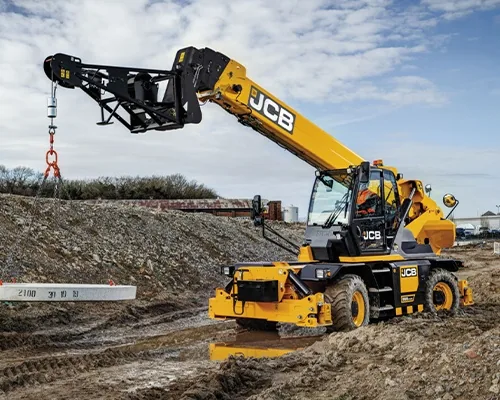 Worker operating machinery at a construction site during safety barrier installation to improve roadside protection.