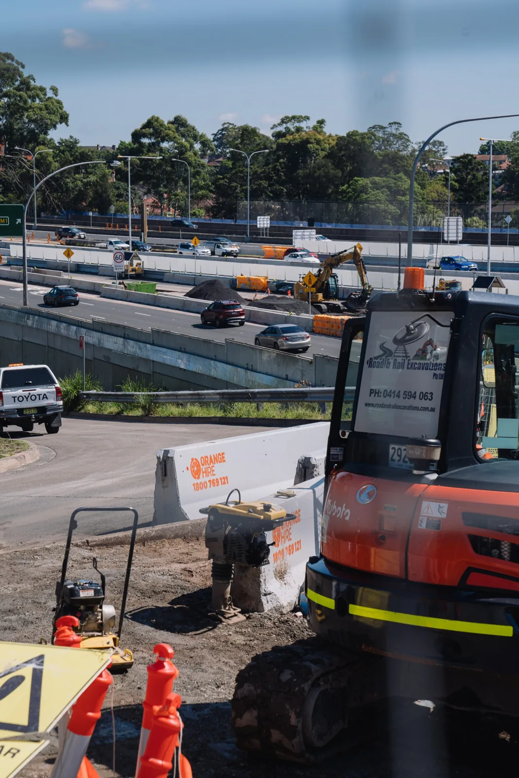 Various types of roadside safety barriers installed along a highway to protect drivers and pedestrians.