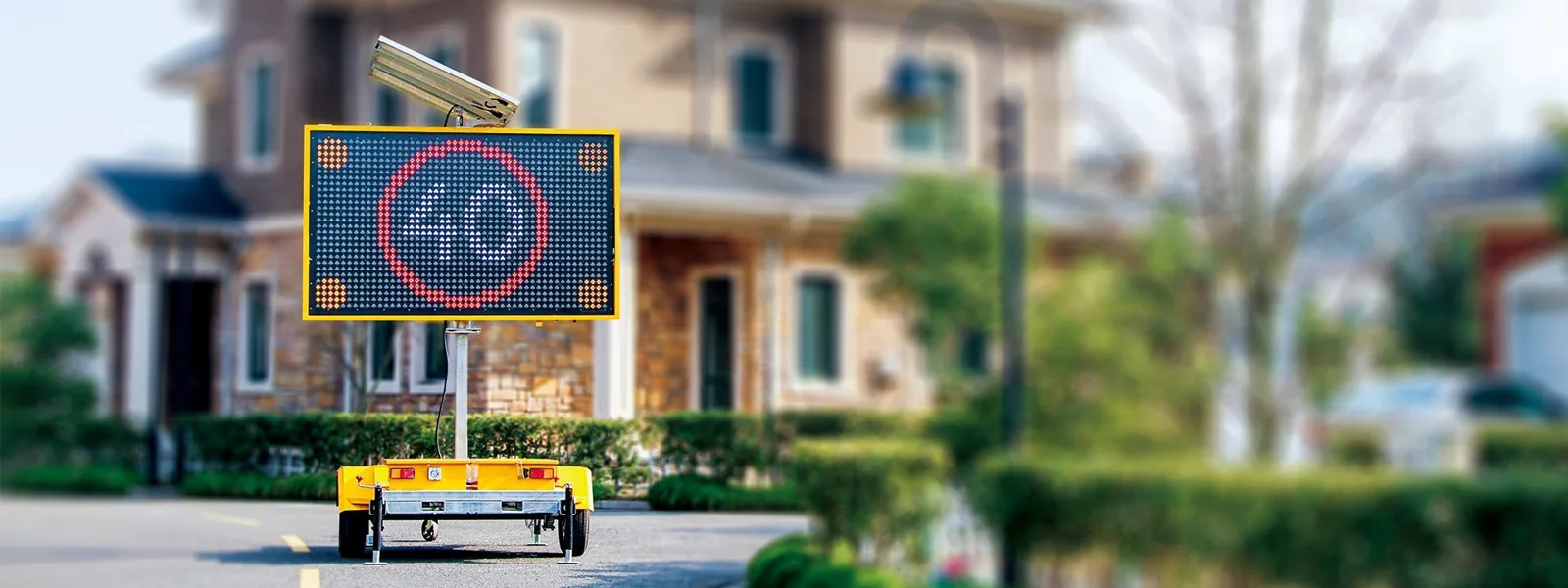 An electronic message board sign on the roadside displaying safety or construction information near a work zone with barriers.