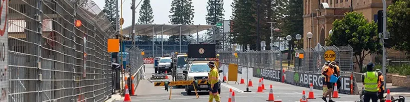 Workers installing pole barriers on a city street to enhance road safety and manage traffic flow.