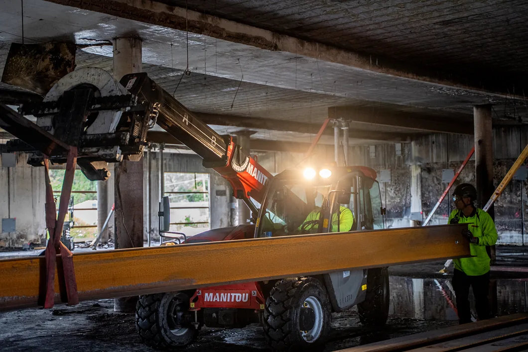 tele handler under ground carpark at night lifting beam